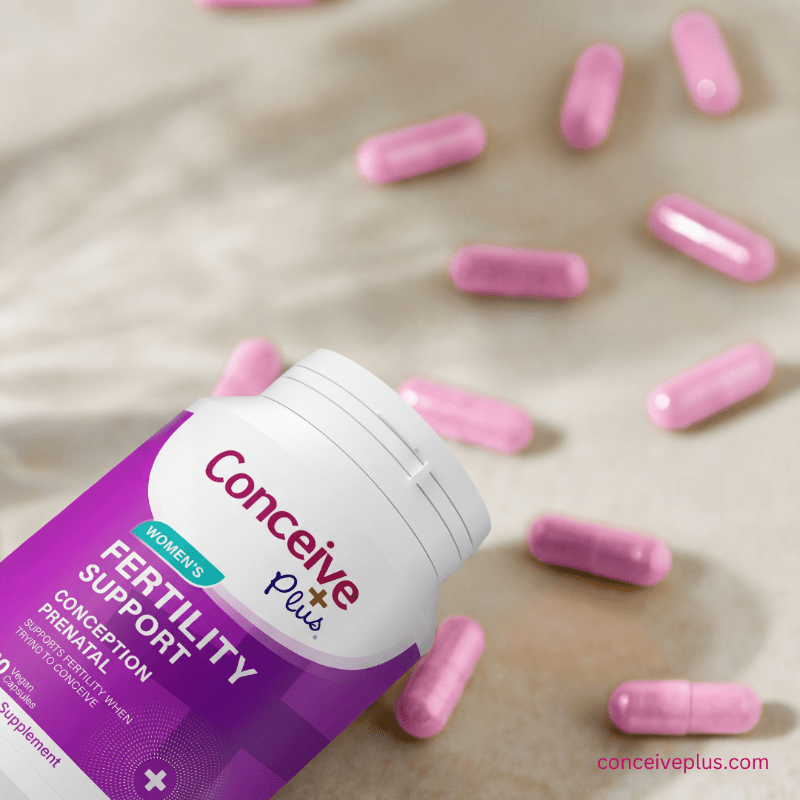 Conceive Plus fertility support supplement bottle with pink capsules on a neutral background