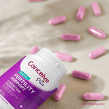 Conceive Plus fertility support supplement bottle with pink capsules on a neutral background